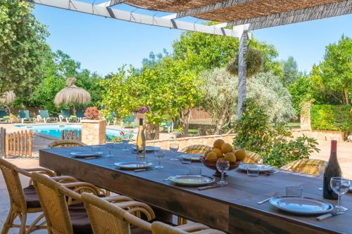 a table with wine glasses and fruit on a patio at Pili in Felanitx
