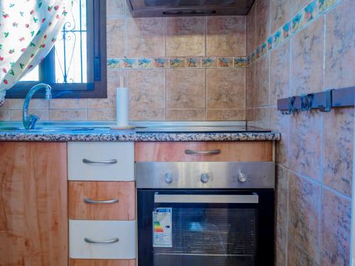 a kitchen with a stove and a sink at Cubo's Casita La Celestina in Alhaurín el Grande