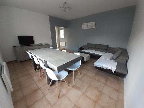 salon ze stołem i kanapą w obiekcie Gite des falaises de Longues 8personnes w mieście Longues-sur-Mer