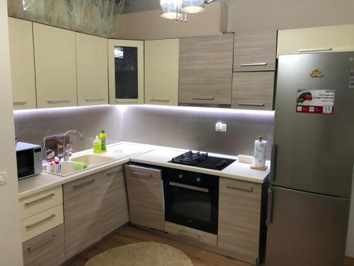 La cuisine est équipée d'un réfrigérateur en acier inoxydable et d'un évier. dans l'établissement VIEW APARTMENT, à Shkodër