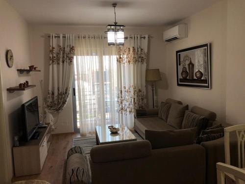 a living room with a couch and a tv at VIEW APARTMENT in Shkodër