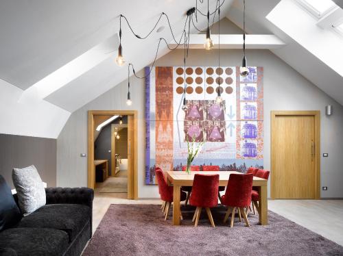 a living room with a table and red chairs at INNSiDE by Meliá Prague Old Town in Prague