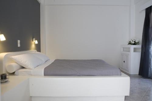 a white bed in a bedroom with a white wall at Philippion Boutique Hotel in Fira
