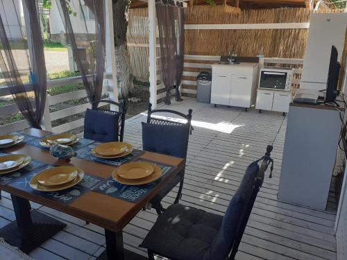 una mesa y sillas en una terraza con cocina en Camping Goldfish, en Sozopol