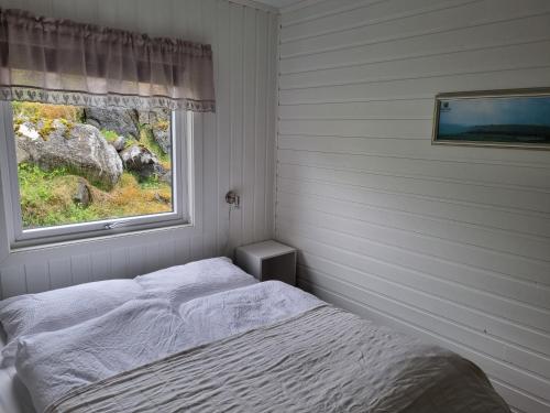 1 dormitorio con cama y ventana en Aktiv ferie i Vesterålen, Hovden 8475 Straumsjøen, en Hovden