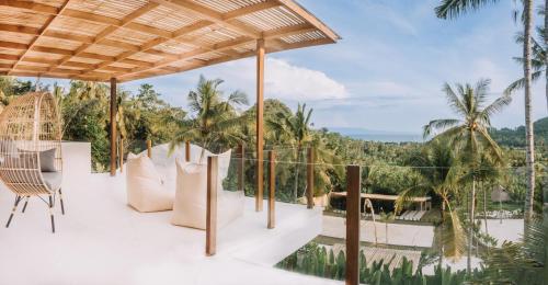 a view from the deck of a resort with palm trees at Neano Escape in Candidasa
