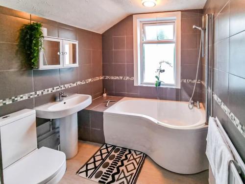 a bathroom with a tub and a sink and a toilet at * Ipswich Suffolk Contractor Holiday Short Stay * in Whitton