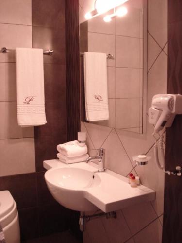 a bathroom with a sink and a mirror and a toilet at il Palazzo Rooms & Suites in Nafplio