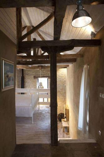 a bedroom with a bed in a room with wooden ceilings at The Four Houses in Kostenkovtsi