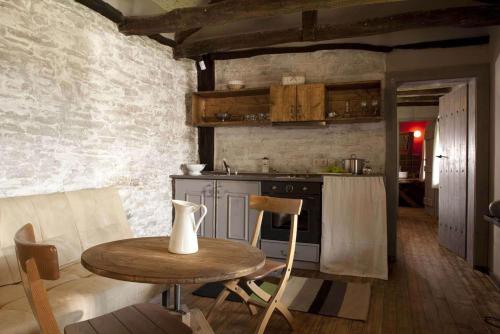 a kitchen with a wooden table and a table and a counter at The Four Houses in Kostenkovtsi