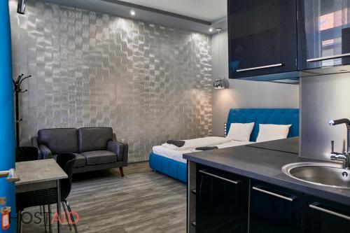 Habitación con cama, sofá y lavamanos en A13 Apartments - Budapest - hostAID en Budapest