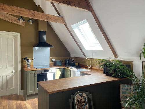 an attic kitchen with a sink and a window at Penarwyn House in Par