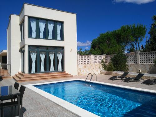 une villa avec une piscine en face d'une maison dans l'établissement Villa Ca Na Llum, à Trebeluger