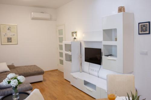 a living room with a white entertainment center at Apartman Maša in Šibenik