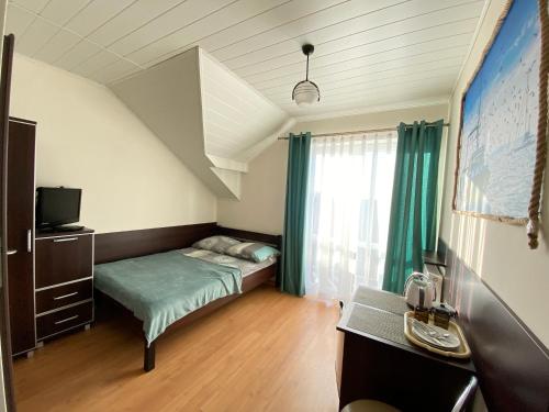 niewielka sypialnia z łóżkiem i oknem w obiekcie Pokoje gościnne Sandra w Ostrowie