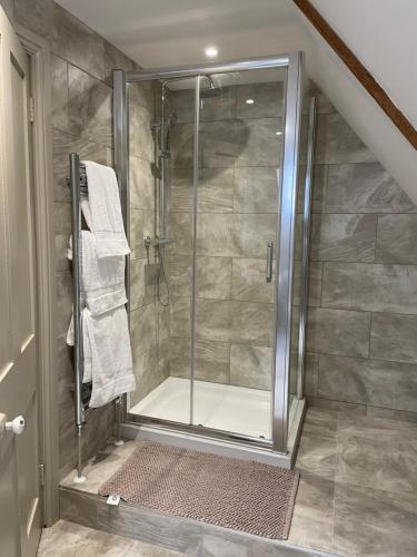 a shower with a glass door in a bathroom at Penarwyn House in Par