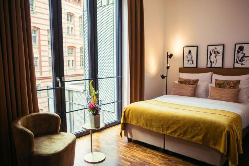- une chambre avec un lit, une chaise et une fenêtre dans l'établissement The Weinmeister Berlin-Mitte - Adults Only, à Berlin
