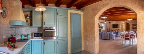 a kitchen with blue cabinets and a living room at Villa Pavicini 2181 in Šegotići