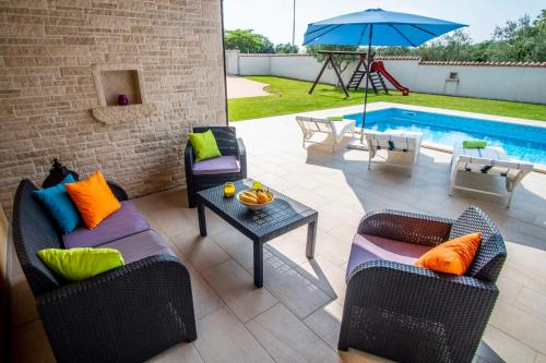 a patio with chairs and a table and a pool at Villa Pavicini 2181 in Šegotići