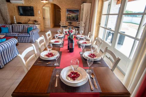 a long table with plates of food and wine glasses at Villa Pavicini 2181 in Šegotići