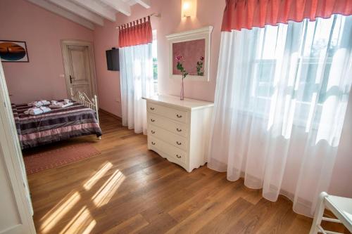 a bedroom with a dresser and a bed and a window at Villa Pavicini 2181 in Šegotići