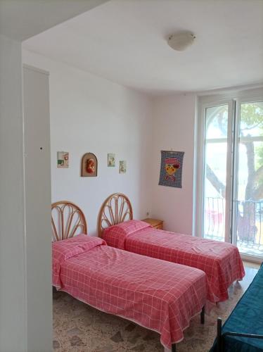 two beds in a room with red sheets at Villa nel Salento - Casa Maria e Casa Glory in Porto Cesareo