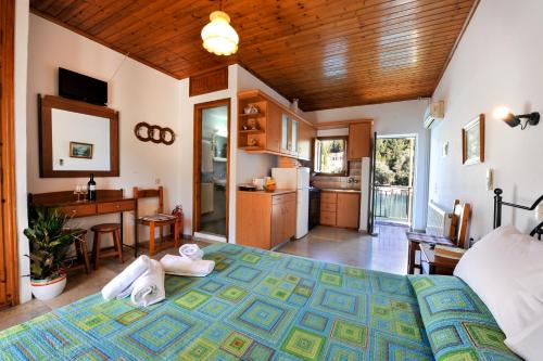 a bedroom with a large bed and a kitchen at Studio Lina in Lákka