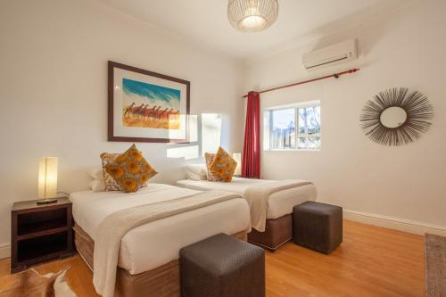 a bedroom with two beds and a mirror on the wall at Inverdoorn Game Reserve Lodge in Breede River DC