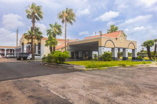 un edificio con palmeras en un aparcamiento en OYO Hotel Corpus Christi North I-37, en Corpus Christi