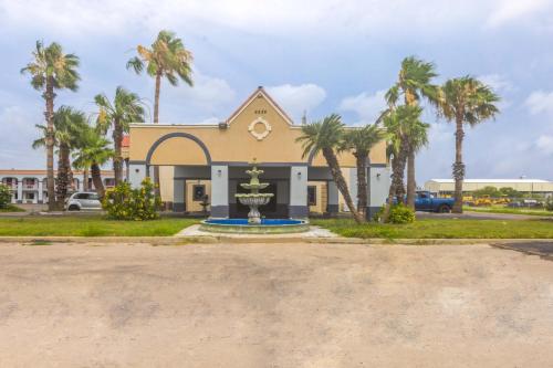 a church with palm trees in front of it at Coastal Inn Corpus Christi in Corpus Christi