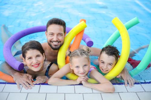 a man and his family playing in a swimming pool at Barack Thermal Hotel and Spa in Tiszakécske