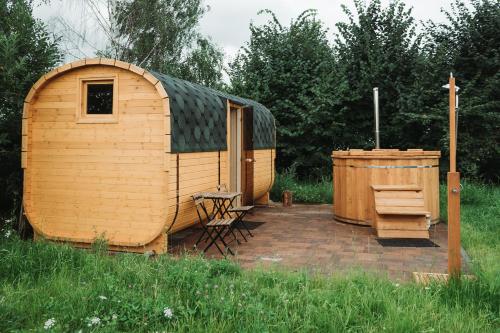 a wooden shed with a bench and a wooden tub at Dom Uzdrowisko in Tolkmicko