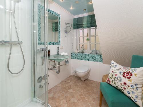 La salle de bains est pourvue d'une douche, de toilettes et d'un lavabo. dans l'établissement Südwind´s Fischerkoje, à Westerland