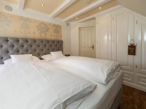 een slaapkamer met een groot bed met witte lakens bij Südwind´s Fischerkoje in Westerland