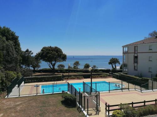 - une vue sur la piscine et l'océan en arrière-plan dans l'établissement LE VALLON, à Pornic