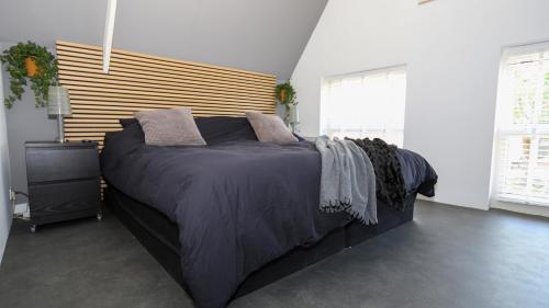 a bedroom with a large bed with a wooden headboard at !!!UNIEK!!! Rijksmonument centrum Harlingen in Harlingen