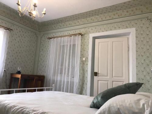 1 dormitorio con cama blanca y puerta blanca en Texas House, en Novaci-Străini