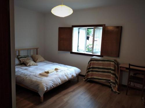 a small bedroom with a bed with a window at Casa de Fundevila in Campo do Gerês