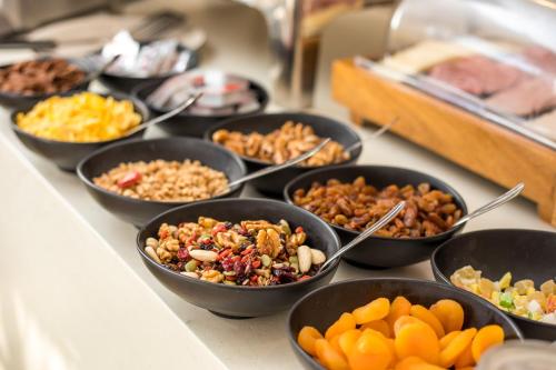 a buffet filled with bowls of different types of food at Atma Beach Rooms & Suites in Faliraki