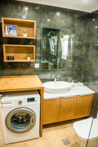 a bathroom with a washing machine and a sink at S & D Apartment in Sitia