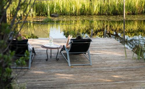 a person sitting in a chair on a dock near the water at Altanure Casa Terra - Ecological Boutique Stay in Tavira
