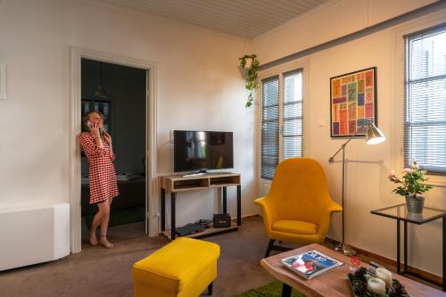 una mujer hablando en un celular en una sala de estar en Greenhouse - Kalamata Mediterranean Villas, en Kalamata