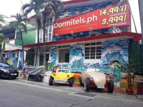 une vieille voiture garée devant un bâtiment dans l'établissement Dormitels.ph The Fort BGC, à Manille