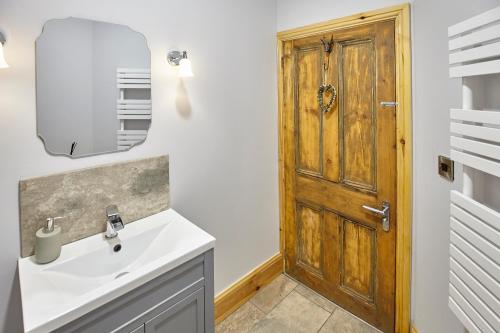 a bathroom with a sink and a wooden door at North England - North Pennines AONB in Westgate