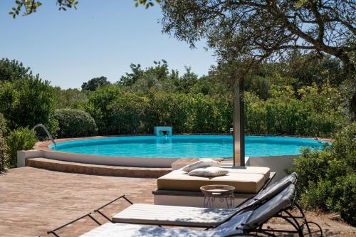 - une piscine avec une chaise longue à côté dans l'établissement Altanure - Casa Terra Ecological Boutique Hotel, à Tavira