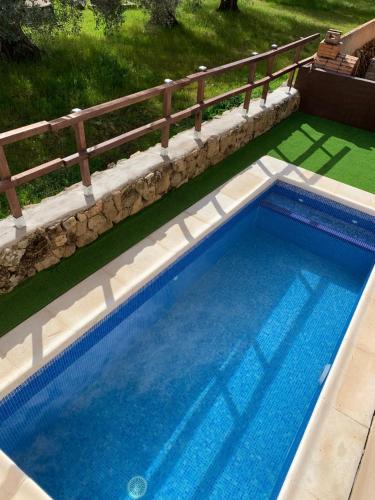 a large swimming pool with a wooden fence around it at El Refugio de Felix in Sotillo de la Adrada