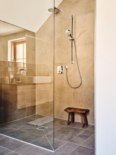 a shower stall with a bench in a bathroom at TAUROA Krenn in Pürgg
