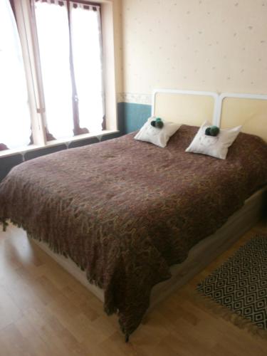 a bedroom with a large bed with two pillows at Meublé de tourisme L'Eau Vive classé 2 étoiles in Plombières-les-Bains