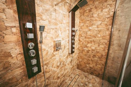 a bathroom with a shower with a stone wall at El Refugio de Felix in Sotillo de la Adrada