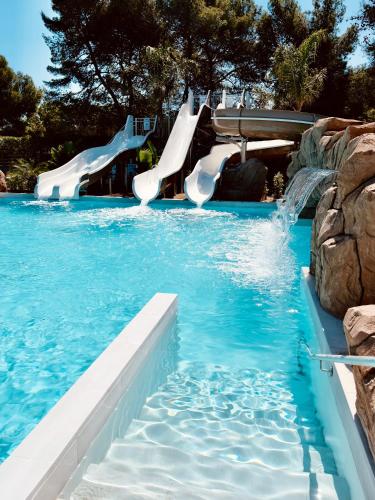 a pool with a water slide in a resort at HolaCamp Sitges Garrofer in Sitges
